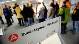 Arbeitslose stehen Schlange bei der Bundesagentur für Arbeit