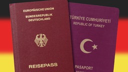 Deutscher und türkischer Reisepass vor einer vor Deutschlandfahne