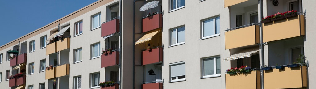 Außenansicht einer Fassade eines Mehrfamilienhauses vor blauem Himmel