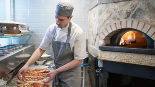 Pizzaiolo backt eine "Pinsa"