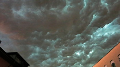 Häuser vor dunklen Unwetterwolken