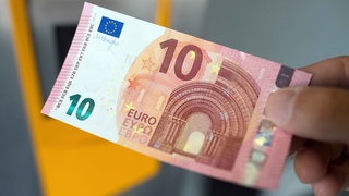 Eine Hand hält einen Zehn-Euro-Schein.