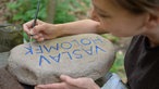 Eine Betreuerin des Sommercamps der Aktion Sühnezeichen arbeitet in Buchenwald (Thüringen) an einem Gedenkstein für ein deportiertes Kind. 