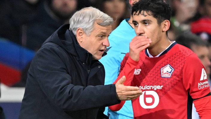 Champions League Szene: Lilles Trainer Bruno Génésio (l) spricht am Spielfeldrand mit Osame Sahraoui (r) (Nahaufnahme)