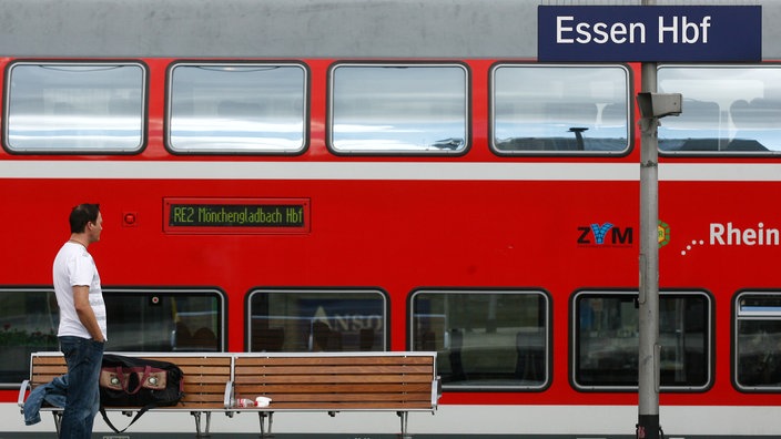 Ein Reisender steht im Hauptbahnhof Essen vor einem Regionalzug