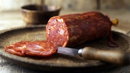 Eine angeschnittene Chorizo liegt auf 