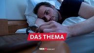 Ein Mann liegt wach im Bett und schaut auf seine Uhr