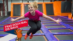 Eine junge Frau springt in einem Trampolinpark