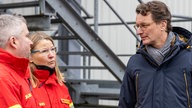 Hochwasser in NRW: Ministerpräsident Hendrik Wüst (r) mit Helfern der DLRG in Vlotho (05.01.2024)