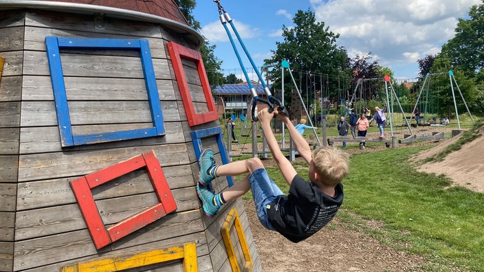 Motorik Fun Park Recke: Ein Junge klettert an einem Seil eine Holzwand hoch