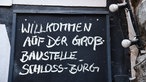 Schloss Burg: Schild mit der Aufschrift "Willkommen auf der Großbaustelle Schloss Burg"