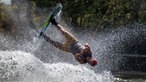 Wakeboardfahrer springt mit seinem Board