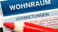 Auf Wohnungssuche: Ein roter Stift auf Vermietungsanzeigen