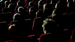 Besucher sitzen in einem Theatersaal