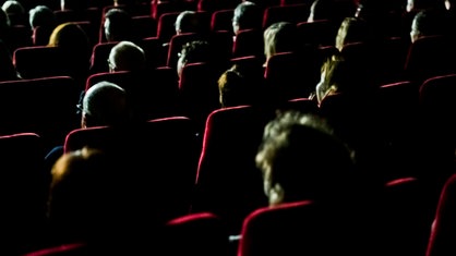 Besucher sitzen in einem Theatersaal