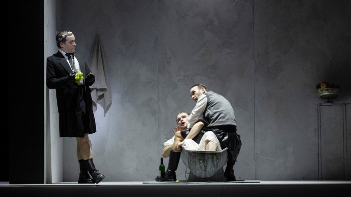 Lawrence Zazzo (Giulio Cesare), Nils Wanderer (Tolomeo in der Wanne liegend) und Jarrett Porter (Curio) in: Händel, „Giulio Cesare“ an der Oper Frankfurt