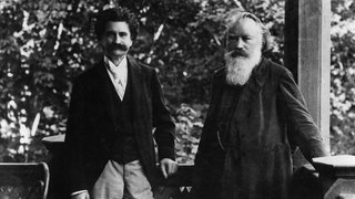 Die Komponisten Johann Strauß (links) und Johannes Brahms (rechts) stehen auf einer Veranda.