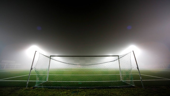 Ein Fußballtor im Nebellicht.