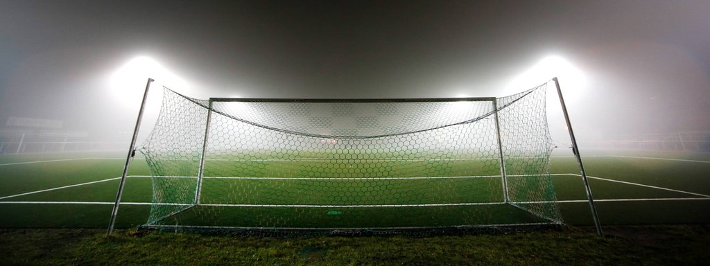 Ein Fußballtor im Nebellicht.