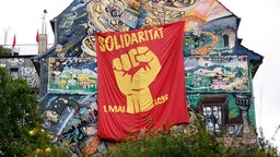 Ein politisches Plakat zur Solidarität am 1. Mai an dem Haus des linksalternativen Projekts LC36.