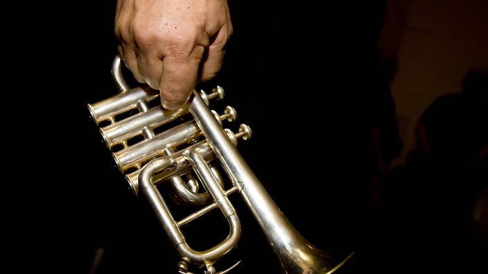 Das Beitragsbild des WDR3 Kulturfeature"Dienst-Schluss! Und dann? Orchestermusiker im (Un)Ruhestand" zeigt eine Männerhand die eine Trompete hält.  