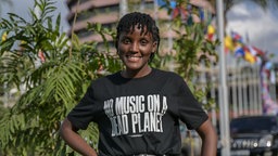 Vanessa Nakata mit einem T-Shirt mit der Aufschrift: "NO MUSIC ON A DEAD PLANET" vor dem Kenyatta International Convention Centre 2023