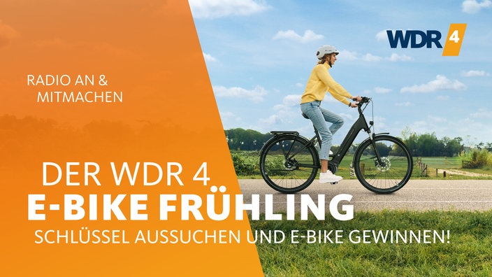 Eine Frau fährt auf einem E-Bike durch eine Landschaft