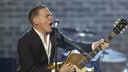 Bryan Adams singt und spielt Gitarre auf der Bühne