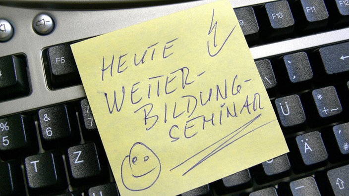 Eine Computer-Tastatur mit gelbem Klebezettel mit dem Text: Heute Weiterbildung- Seminar