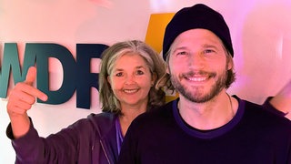 Sebastian Ströbel und Heike Knispel vor dem WDR 4-Logo