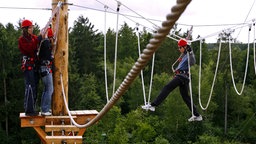 Menschen blancieren durch einen Kletterpark