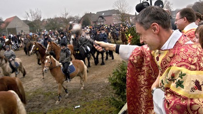 Der Pastor Heinz-Norbert Hürter segnet am 26.12.2006 in Goch-Kessel Reiter und Pferde an der St. Stephanus Kirche.