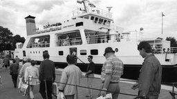 Passagiere beim Verlassen des Schiffes "Adler Pomerania" mit Einkaufstüten voll zollfreier Waren in dem kleinen Hafen des vorpommerschen Ortes Altwarp.