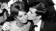 Der amerikanische Schauspieler Anthony Perkins küsst am 19.05.1961 bei den Filmfestspielen in Cannes in Frankreich seine italienische Kollegin Sophia Loren auf die Wange.