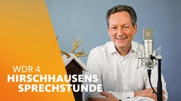 Dr. Eckart von Hirschhausen sitzt neben einem Vogelhaus und vor einem Mikrofon