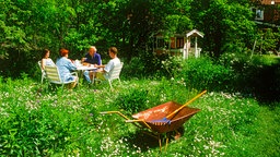 Familie beim Kaffee nach der Gartenarbeit