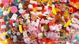 Verschiedene Sorten von Fruchtgummis, Zuckerschaum, Marshmallows, Mäusespeck, Bonbons, Drops, Lutscher, Kekse und Gummibärchen.