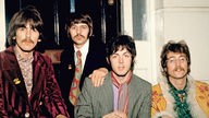 The Beatles sitzen 1967 zusammen auf einer Party