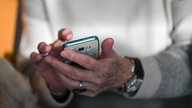 Seniorin hält ein Smartphone