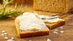 Frisches Brot mit Butter, Meersalz und einem Rosmarinzweig