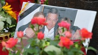 Bild von Dominik Brunner zwischen Kerzen und Blumen