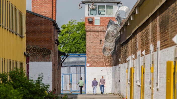 Das Beitragsbild des Dok5 "Ersatzfreiheitsstrafe - Streit um den Schuldturm für Arme" zeigt zwei Gefängnisinsassen auf dem Anstaltsgelände der Justizvollzugsanstalt Werl.