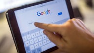 Hand tippt auf Tablet mit geöffneter Google-Seite