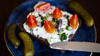 Schwarzbrot mit Gewürzgurken, Tomaten, Zwiebeln und Quark