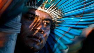 Ein Mann mit Federschmuck bei einer Demonstration für die Rechte indigener Völker vor dem Justizministerium in Brasilia im Mai 2014