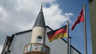 Das Minarett der Wuppertaler Moschee - daneben wehen die deutsche und türkische Fahne im Wind