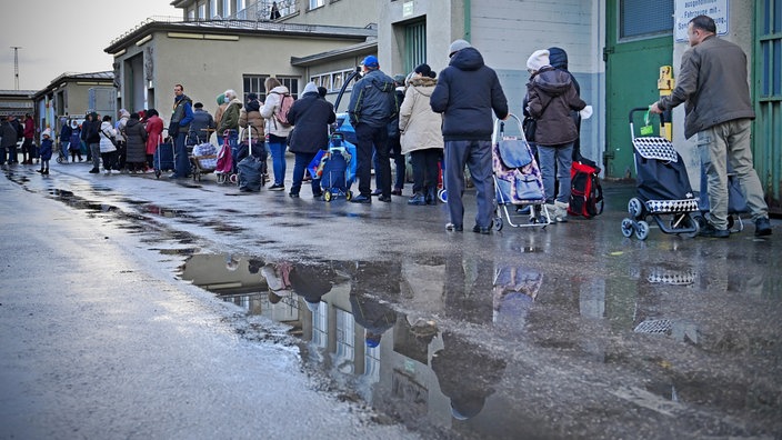 Das Beitragsbild des Dok5 "Tafeln, Foodbanks, Suppenküchen - Bestandsaufname der Almosenwirtschaft" zeigt wartende Menschen vor der Muenchner Tafel auf dem Grossmarkt Muenchen. 