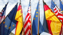 Die deutsche, amerikanische und EU-Flagge vor dem Bundeskanzleramt.