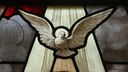 Eine Taube als Symbol des Heiligen Geistes auf einem Buntglasfenster in einer Kirche