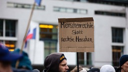 Bei einer Demonstration gegen Rechts hält ein Mensch ein Schild hoch mit der Aufschricht "Menschenrechte statt reche Menschen" (14.01.2024)